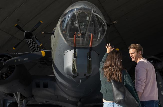 A young couple looking at the nose of the B-17 Flying Fortress in the American Air Museum at IWM Duxford