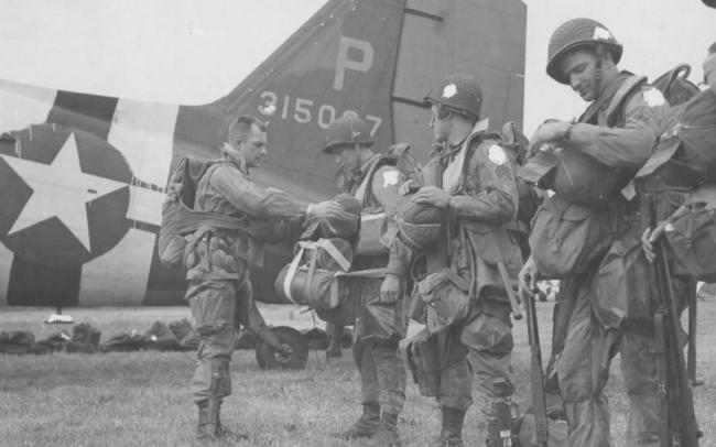 US paratroopers check their kit before boarding for France.