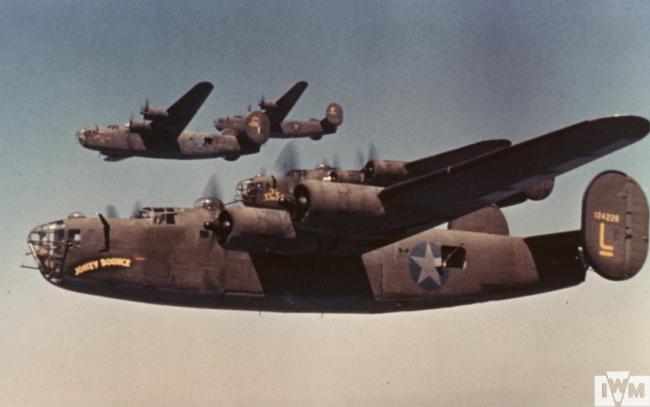 B-24 Liberators, including (serial number 41-24226 ) nicknamed "Joisey Bounce" of the 93rd Bomb Group fly in formation during a mission.