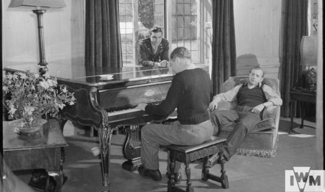 "Doc" Kennedy plays the piano before changing for dinner in comfortable surroundings of the piano room at Stanbridge Earls. 